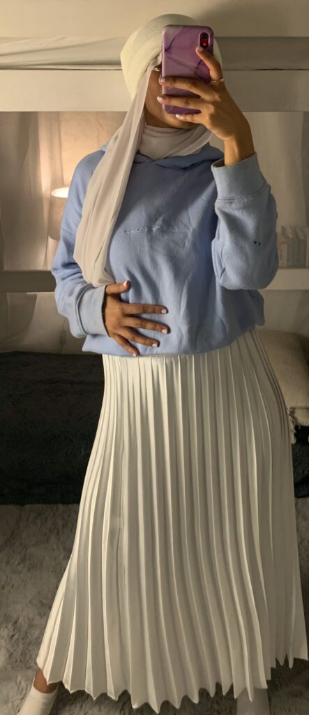 beanie hijab look with blue over sized hoodie and a white silk pleated skirt